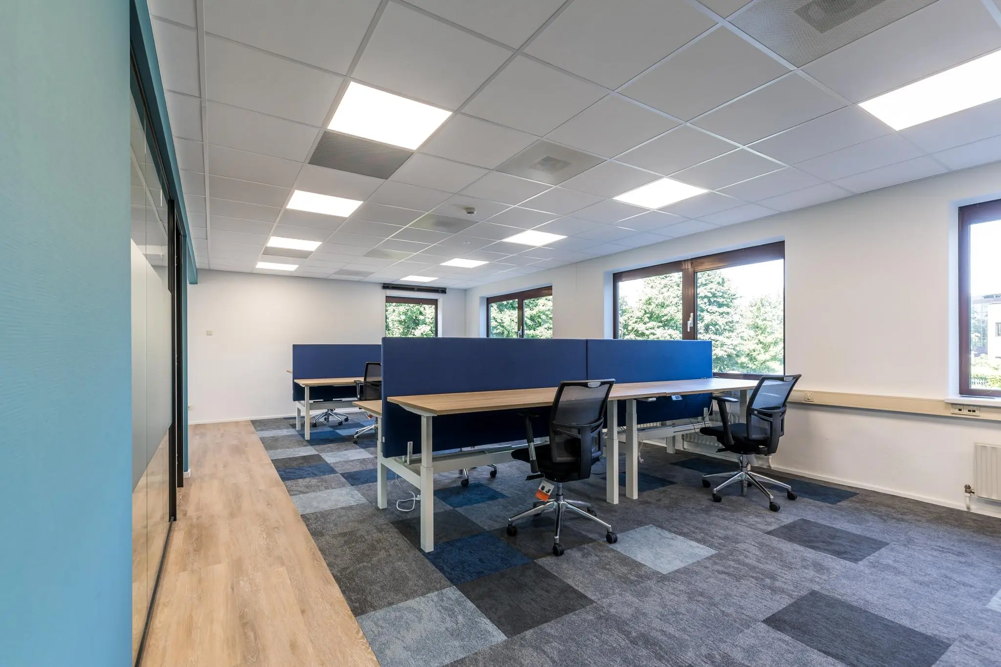 Modern kantoor met werkplekken en bureaustoelen aan de Baarnsche Dijk, met veel daglicht en een strak interieur.